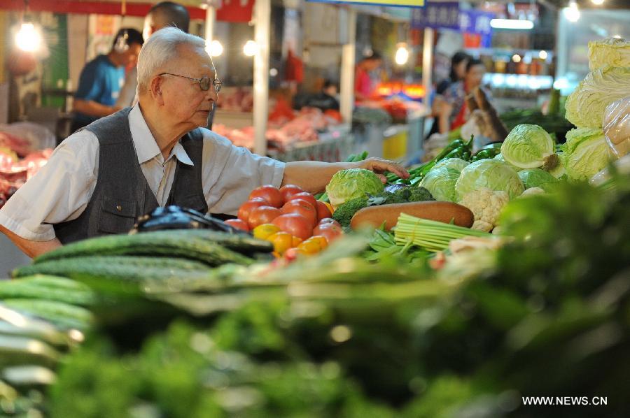 A citizen selects vegetables at a market in Changchun, capital of northeast China's Jilin Province, July 9, 2013. China's consumer price index (CPI), a main gauge of inflation, grew 2.7 percent year on year in June, up from 2.1 percent in May, the National Bureau of Statistics said on Tuesday. (Xinhua/Zhang Nan) 