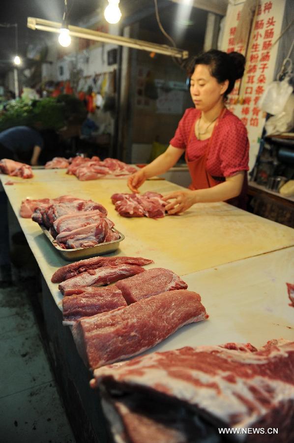 A seller arranges meat at a market in Changchun, capital of northeast China's Jilin Province, July 9, 2013. China's consumer price index (CPI), a main gauge of inflation, grew 2.7 percent year on year in June, up from 2.1 percent in May, the National Bureau of Statistics said on Tuesday. (Xinhua/Zhang Nan) 
