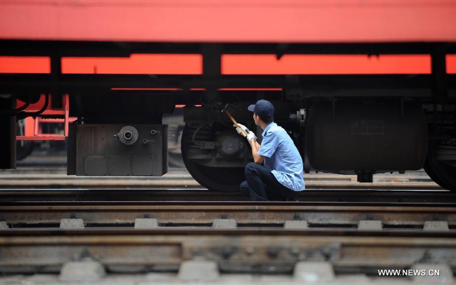 A staff member from the maintenace crew checks a train in Chengdu, capital of southwest China's Sichuan Province, July 8, 2013. Known as the "Train Hospital", the maintenance crew provide 24-hour-services for examining and cleaning trains. (Xinhua/Xue Yubin)