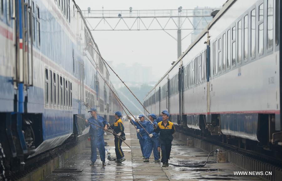 Staff members from the maintenace crew clean a train in Chengdu, capital of southwest China's Sichuan Province, July 8, 2013. Known as the "Train Hospital", the maintenance crew provide 24-hour-services for examining and cleaning trains. (Xinhua/Xue Yubin)