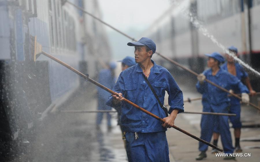 Staff members from the maintenace crew clean a train in Chengdu, capital of southwest China's Sichuan Province, July 8, 2013. Known as the "Train Hospital", the maintenance crew provide 24-hour-services for examining and cleaning trains. (Xinhua/Xue Yubin)
