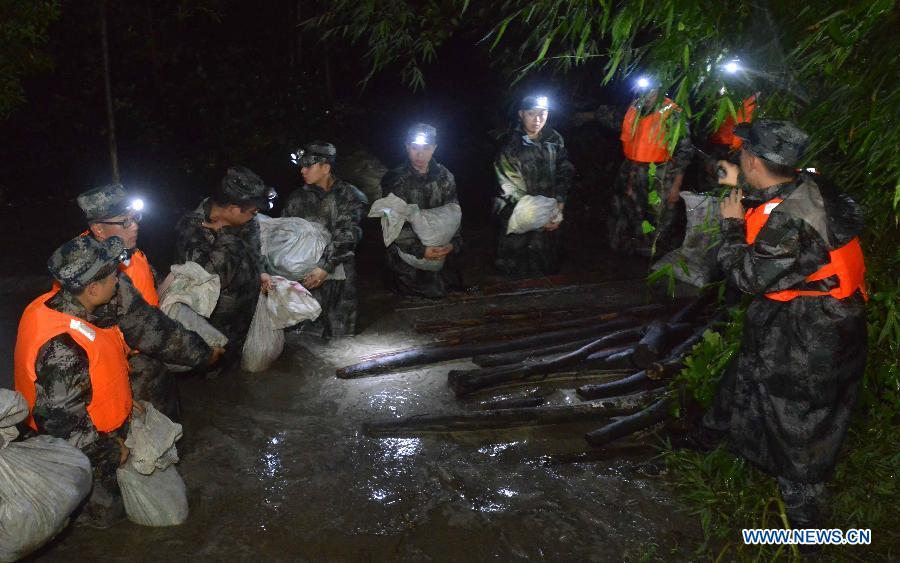 Soldiers take part in emergency rescue in Jiujiang Town of Chengdu City, capital of southwest China's Sichuan Province, July 9, 2013. The Jiang'an River busted its bank due to a rainstorm on Tuesday. The residents have been evacuated and the situation is under control by now. (Xinhua/Peng Guangxian)