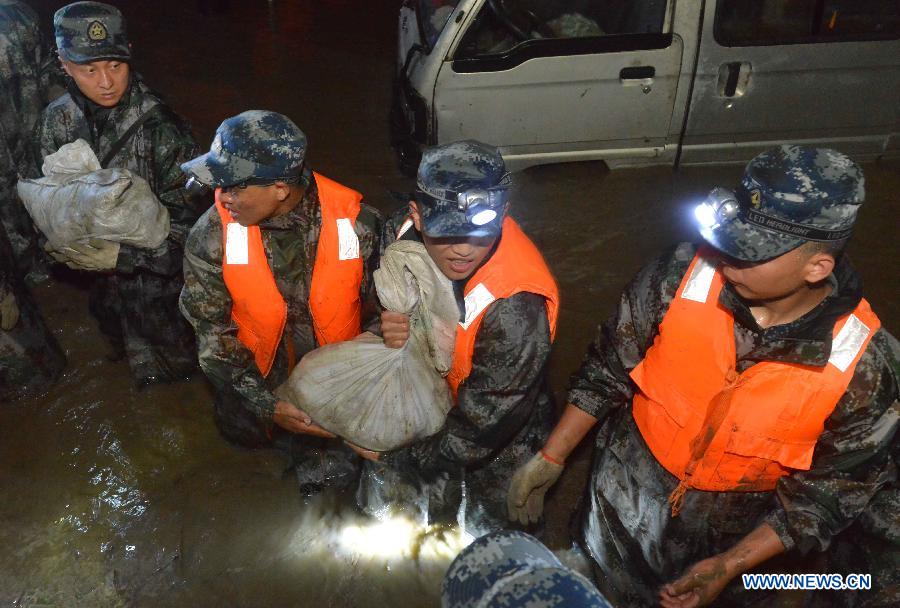 Soldiers take part in emergency rescue in Jiujiang Town of Chengdu City, capital of southwest China's Sichuan Province, July 9, 2013. The Jiang'an River busted its bank due to a rainstorm on Tuesday. The residents have been evacuated and the situation is under control by now. (Xinhua/Peng Guangxian)
