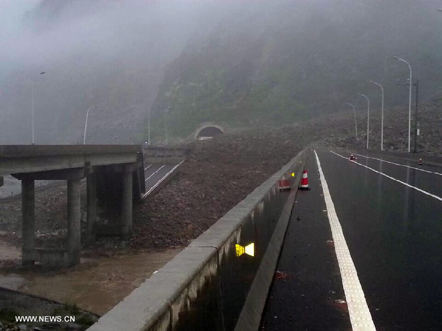 Photo taken with a mobile phone shows a rain-triggered landslide crushing a bridge on Duwen Expressway in Wenchuan County, southwest China's Sichuan Province, July 10, 2013. Rainstorms battered the county in these two days. (Xinhua/Lu Guotong)