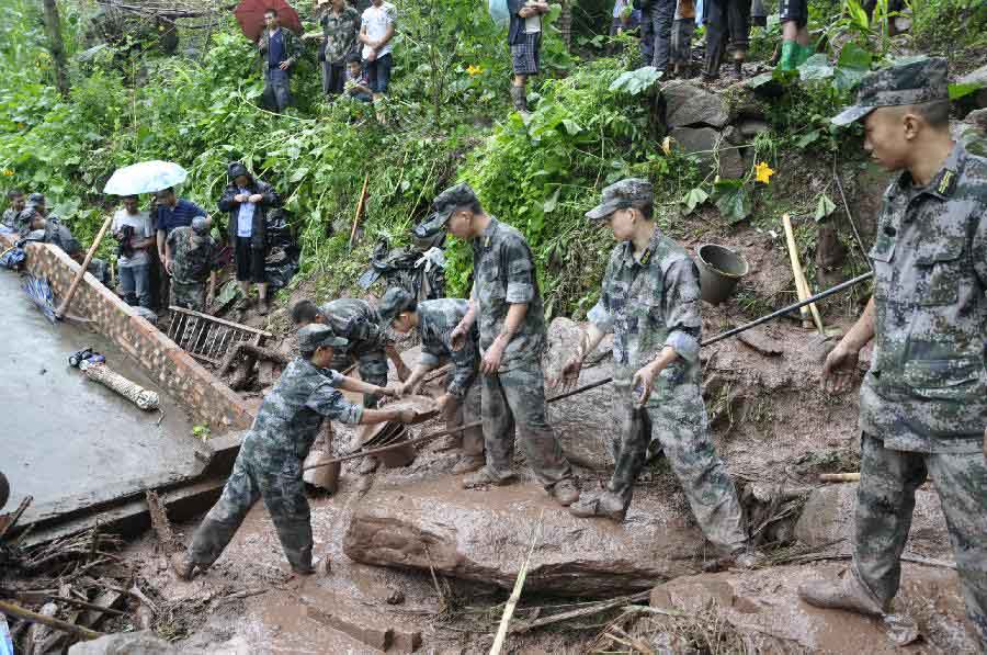 Rescuers clear the debris at flood-hit Huiwang Village of Suijiang County, southwest China's Yunnan Province, July 10, 2013. Rain-triggered mountain torrents and landslides hit five townships of the county in these two days, leaving four people dead. (Xinhua/Tan Pingcai) 