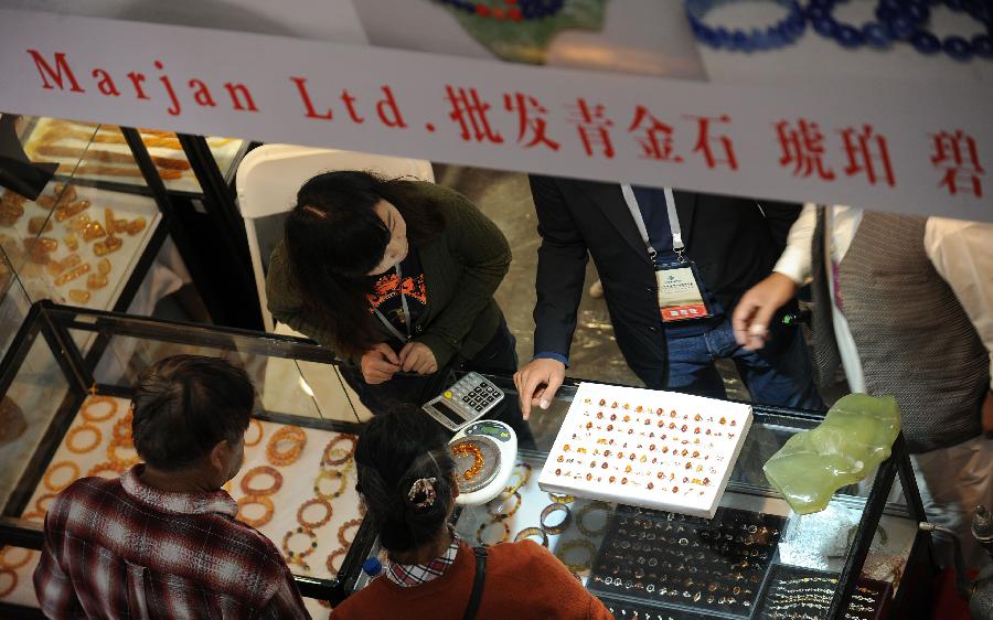 Visitors select jade accessories at the 2013 China Pan-Asia Stone Expo in Kunming, capital of southwest China's Yunnan Province, July 10, 2013. The eight-day expo kicked off Wednesday at the Kunming International Convention and Exhibition Center. (Xinhua/Qin Lang)