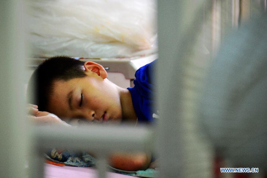 A boy suffering from dengue fever rests in bed at a hospital in Vientiane, Laos, July 10, 2013. The Lao government announced on Monday the release of 2 billion kip (about 250,000 U.S.dollars) to combat the spread of dengue fever in the country, local media reported. Director General of the Communicable Disease Control Department of the Lao Ministry of Health Dr. Bounlay Phommasack said that in the first six months of this year 20,367 infections, with 64 deaths, were reported.(Xinhua/Allen Liu)
