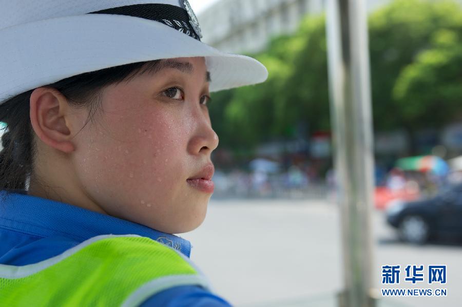 Traffic policewoman Wang Jingjing stays on duty on July 4, 2013, in Nanchang, central China's Jiangxi province. The highest temperature in Nanchang reached 35 degrees Celsius. (Xinhua/Hu Chenhuan)