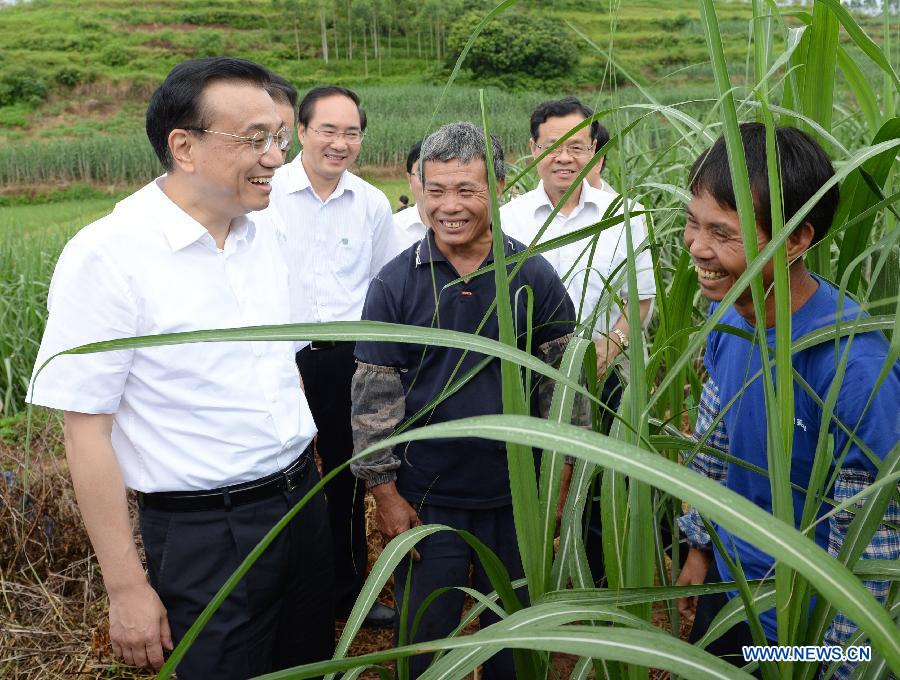 Chinese Premier Li Keqiang (L front) talks with farmers at a sugarcane plantation in Chongtao Village, Nanning, capital of south China's Guangxi Zhuang Autonomous Region, July 9, 2013. Li made a research tour in Guangxi from July 8 to 10. (Xinhua/Ma Zhancheng)