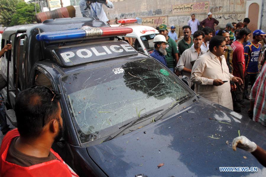 Security officials inspect a damaged police van at the suicide blast site in southern Pakistani port city of Karachi on July 10, 2013. Pakistani President Asif Ali Zardari's chief security officer Bilal Ahmad Sheikh was killed in a suicide bomb blast in Karachi on Wednesday, police said.
