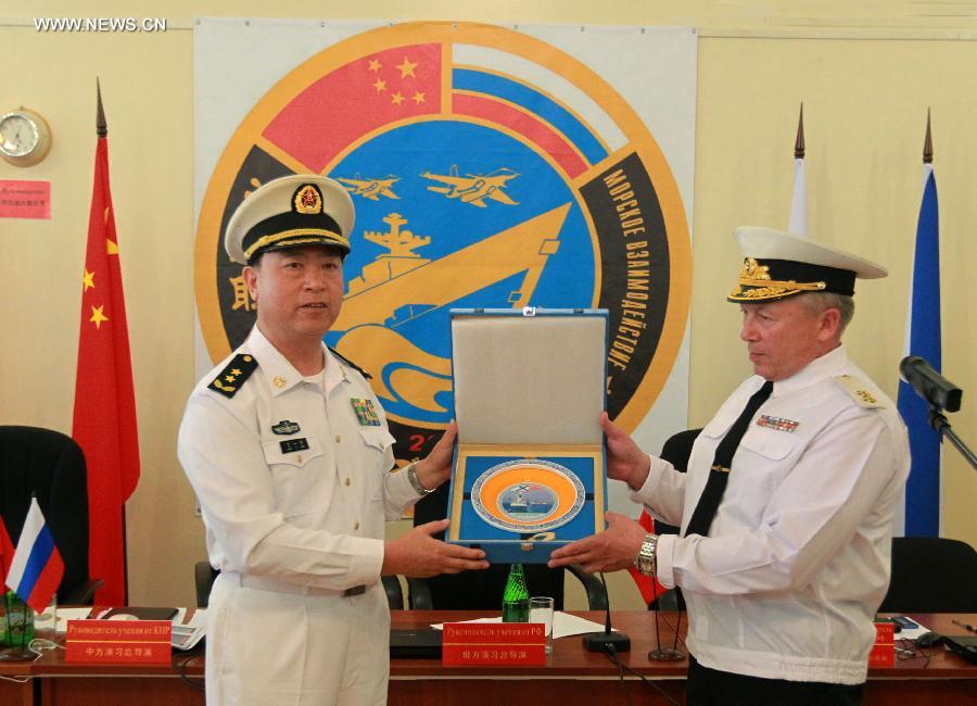 Directors of "Joint Sea-2013" drill from China and Russia exchange gifts at the closing ceremony of the joint naval drills in Vladivostok, Russia, July 11, 2013. Ding Yiping, deputy commander of the Chinese Navy and director of the "Joint Sea-2013" drill, announced the end of the joint naval drills here on Thursday. (Xinhua/Zha Chunming) 