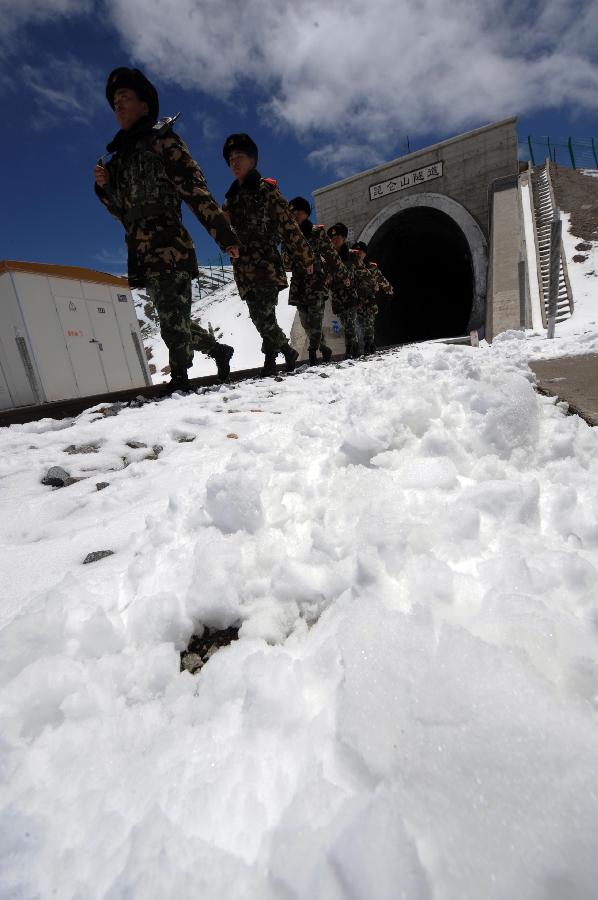 Armed policemen patrol along the Qinghai-Tibet Railway at the 1,686-meter Kunlun Mountain Tunnel in northwest China's Qinghai Province, July 9, 2013. The armed policemen overcome the harsh climate and lack of oxygen, and stick to their post. (Xinhua/Hou Deqiang)