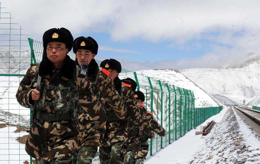 Armed policemen patrol along the Qinghai-Tibet Railway in northwest China's Qinghai Province, July 9, 2013. The armed policemen overcome the harsh climate and lack of oxygen, and stick to their post. (Xinhua/Hou Deqiang)