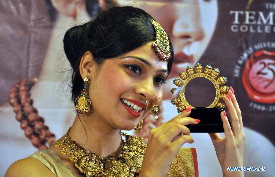 A model displays jewelry of ancient temples of India during the exhibition "Temple Collection" in Bhopal, India, July 11, 2013. (Xinhua/Stringer)