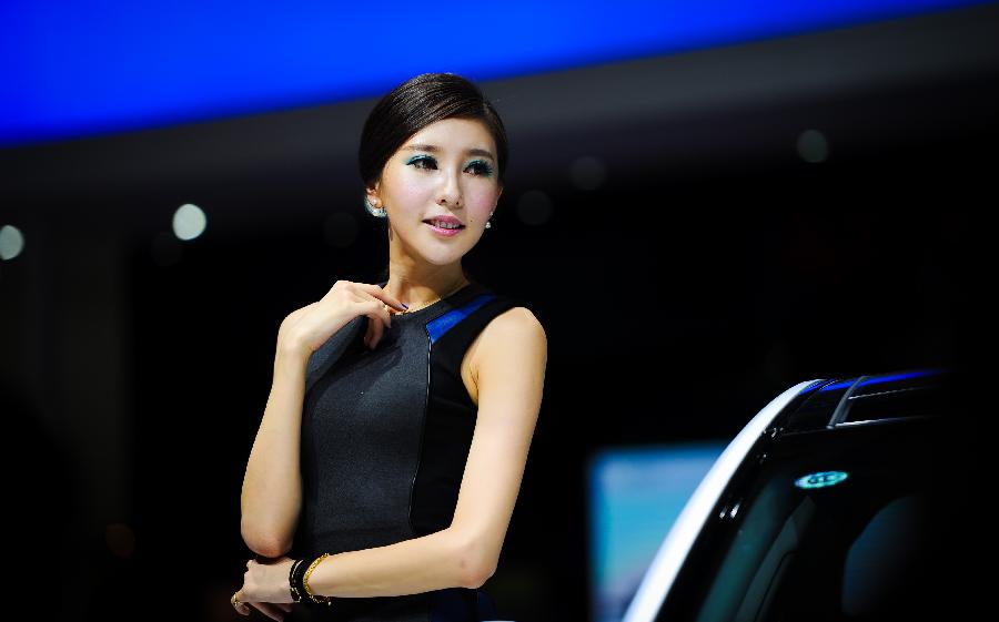 A model presents a vehicle at the 10th China Changchun International Automobile Expo in Changchun, capital of northeast China's Jilin Province, July 12, 2013. The ten-day expo kicked off here on Friday. (Xinhua/Xu Chang)