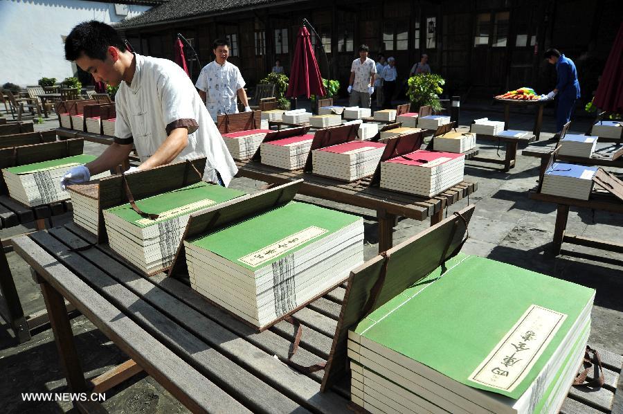 Staff members place books in the sun at the Yunhe Academy of Classical Learning in Hangzhou, capital of east China's Zhejiang Province, July 13, 2013. A book sunning festival was held at the academy to mark the tradition among ancient Chinese intellectuals to dry books in the sun on the sixth day of the sixth month of the lunar calendar, which falls on July 13 this year. (Xinhua/Xu Hui) 