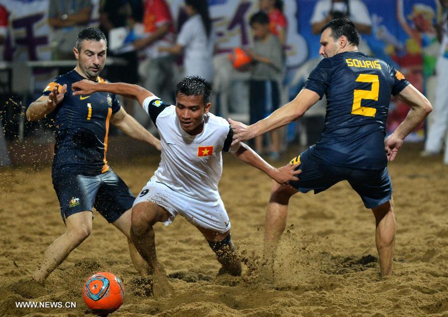Phung Tan Hung (C) of Vietnam competes during the men's beach soccer match against Australia at the 4th Asian Beach Games in Haiyang, east China's Shandong Province, July 11, 2013. Vietnam lost 2-7. (Xinhua/Zhu Zheng)
