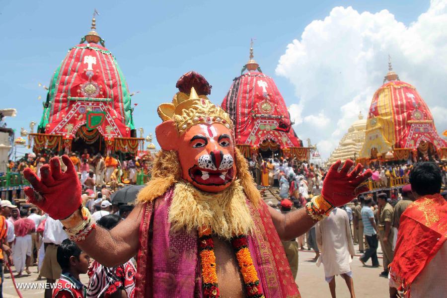 A masked dancer attends the religious Hindu festival Rath Yatra (holy chariot procession) of Lord Jagannath, in the eastern Indian state of Orissa's holy town of Puri, July 10, 2013. (Xinhua/Stringer)