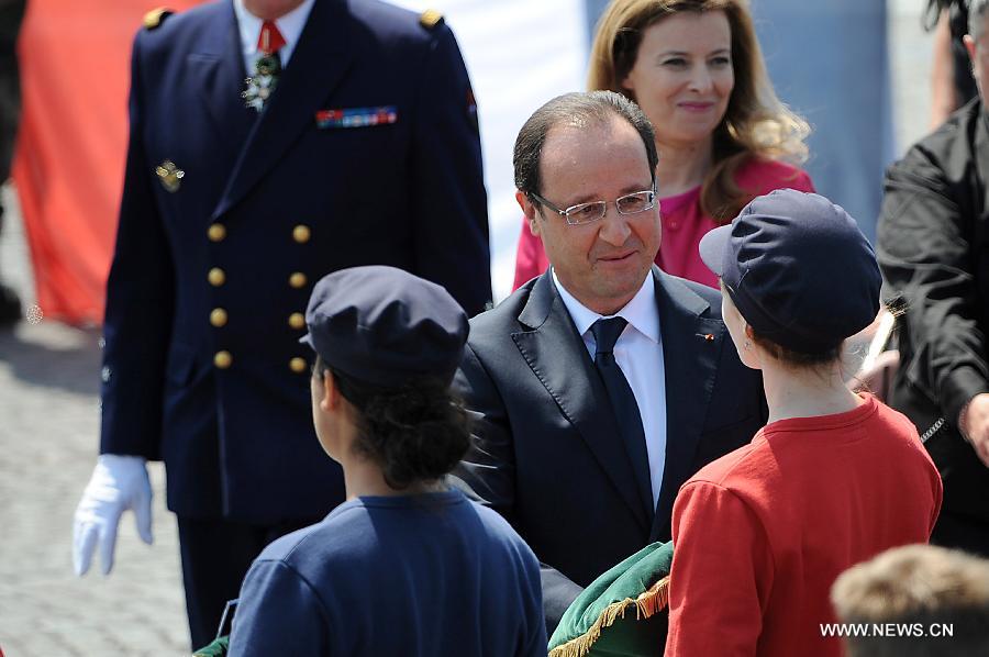 French President Francois Hollande (C) shakes hands with a woman after the Bastille Day military parade in Paris, France, on July 14, 2013. (Xinhua/Etienne Laurent) 