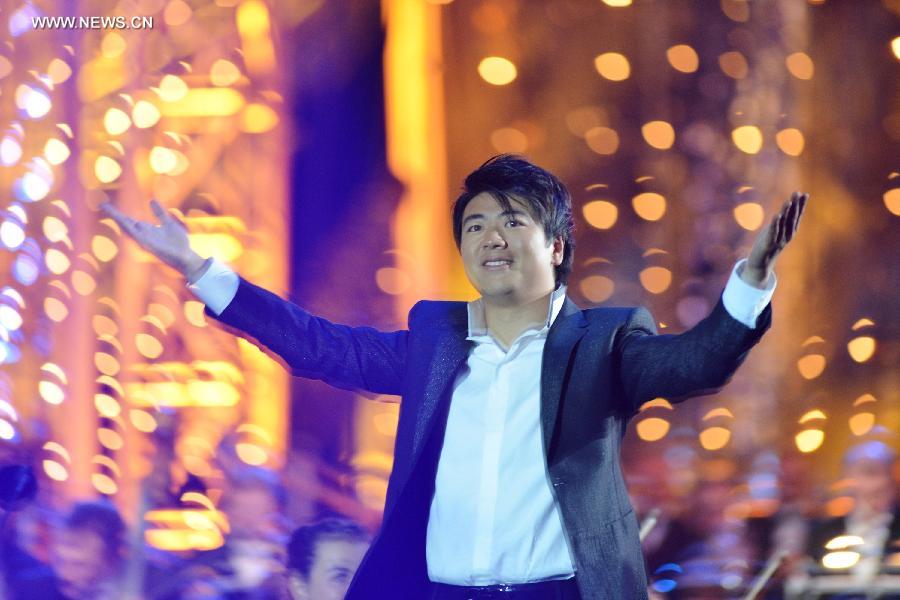 Chinese pianist Lang Lang greets the audience after playing piano during the national day concert held in Paris, France, on July 14, 2013. (Xinhua/Li Genxing)