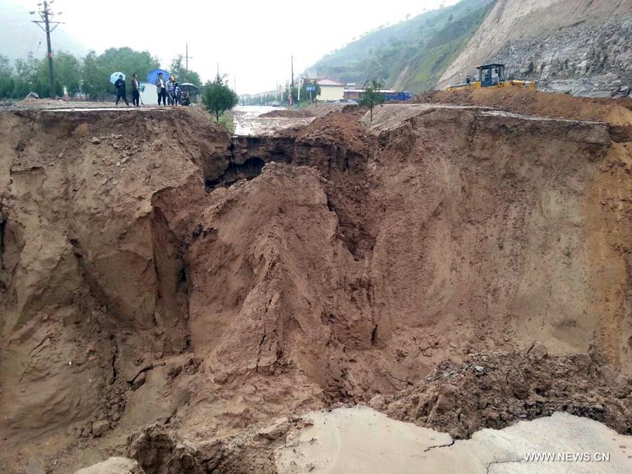 Photo taken on July 15, 2013 shows the collapsed road destroyed by a rain-triggered floods in Fanjiachuan Village of Qingyang City, northwest China's Gansu Province. Two people were killed, one was injured and six others were reported missing in the rain-triggered floods. Rescue work is underway. (Xinhua/Li Pengbo)