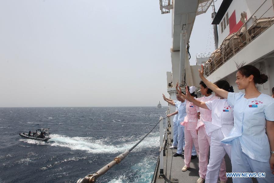 Medical personals on Chinese People's Liberation Army Navy hospital ship "Peace Ark" wave to soldiers from Netherlands' Van Speijk vessel in Gulf od Aden, July 14, 2013. It was the first time PLA Navy hospital ship "Peace Ark" provided medical treatment for foreign soldiers during its 10-day mission to Gulf of Aden. (Xinhua/Ju Zhenhua)