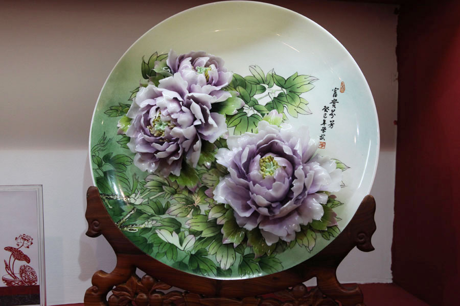 Porcelain artwork featuring the pattern of peony flowers is shown at the 2013 China International Consumer Products Exhibition. (CRIENGLISH.com/Wang Wei)