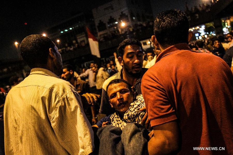 Supporters of ousted Egyptian President Mohamed Morsi carry an injured protester in Ramsis square, downtown Cairo, Egypt on July 15, 2013. Clashes erupted between pro-Morsi protesters and riot police when police force fired teargas and rubber bullets at a pro-Morsi march heading to Giza square, at least 100 protesters are injured, according the official Egyptian Ambulance Organization. (Xinhua/Amru Salahuddien)