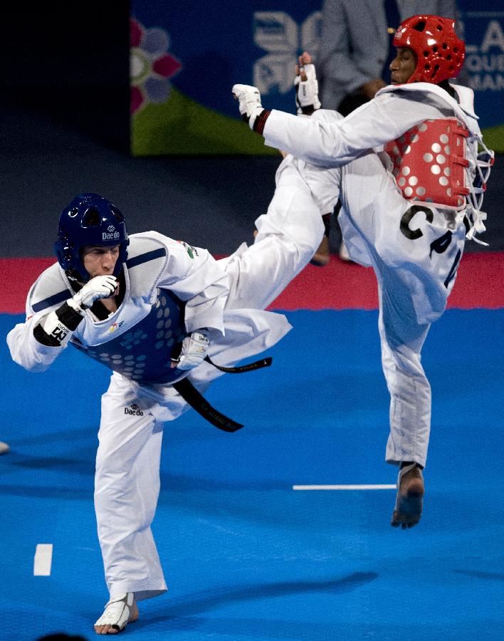 Arindo Semedo (R) from Cape Verde, blocks a kick during his combat against Damian Villa (L) from Mexico in the 58 kg men's category of the Taekwondo World Championship of the World Taekwondo Federation (WTF), in the Expositions and Coventions Center of Puebla, in Puebla, Mexico, on July 15, 2013 (Xinhua/Guillermo Arias)