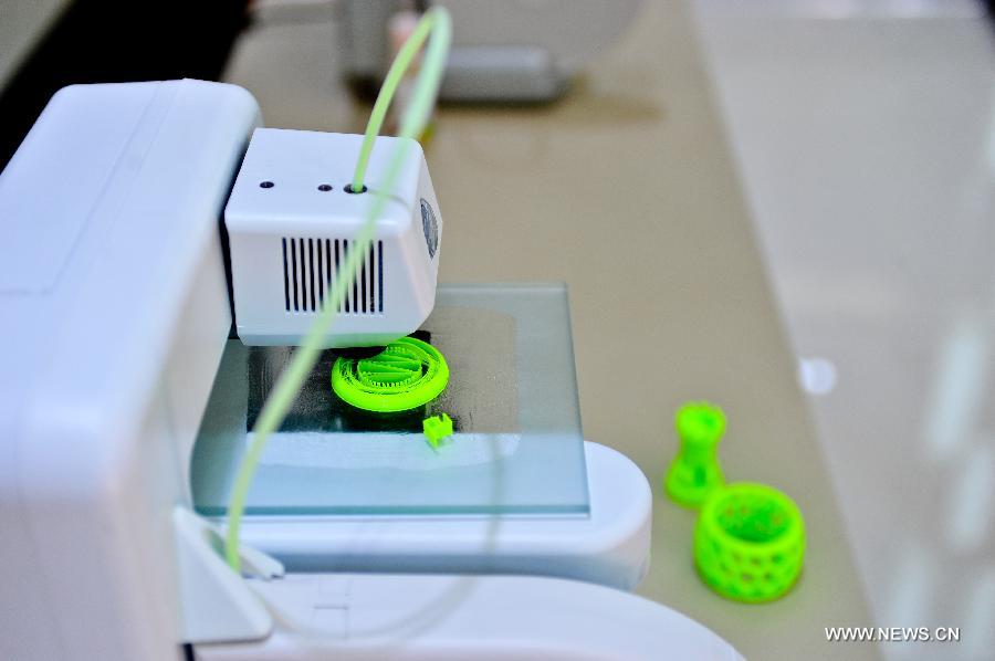 A plastic cup is being made at a 3D-printing experience store in Tianjin, north China, July 16, 2013. (Xinhua/Zhai Jianlan)  