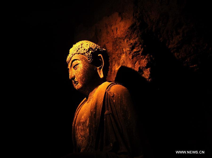 Photo taken on July 15, 2013 shows a sculpture at the Maiji Mountain Grottoes in Tianshui, northwest China's Gansu Province. After protection and preparation, the Maiji Mountain Grottoes, the fourth largest grottoes in China and known as the "Oriental Sculpture Museum", has been ready for the application for status on the World Heritage List in 2014, as a part of the application program of the 2,000-year-old Silk Road which China works with Kazakstan and Kyrgyzstan and was officially submitted to the United Nations Educational, Scientific and Cultural Organization (UNESCO) in January of 2013. China has altogether 22 historical sites in this application program, including seven in Xinjiang, five in Gansu, six in Shaanxi and four in Henan. (Xinhua/Nie Jianjiang) 