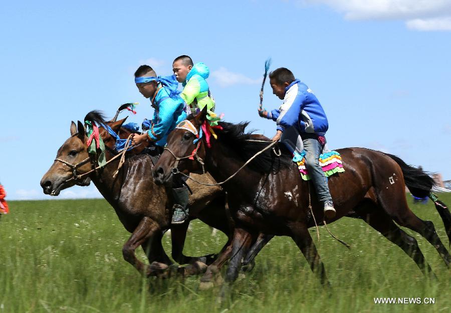 Herdsmen are seen in a horse race at the White Horse Festival in the West Ujimqin Banner of north China's Inner Mongolia Autonomous Region, July 16, 2013. With rodeos and races, the White Horse Festival will last two days .(Xinhua/Ren Junchuan) 