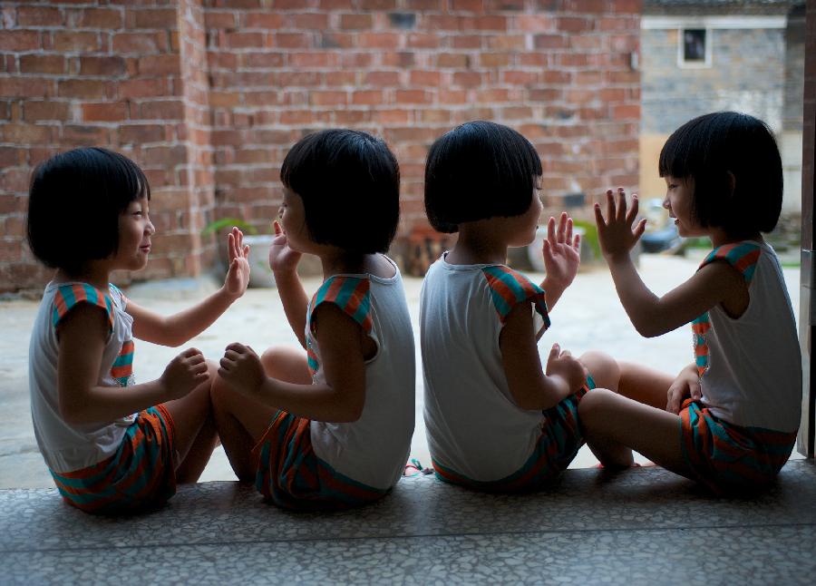 The quadruplet sisters play outside of home. (Xinhua/Hu Chenhuan) 