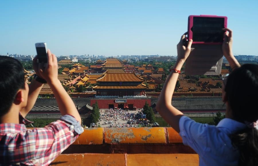 Tourists take photo of scenery of Jingshan Park in Beijing, capital of China, July 16, 2013. After a few days of rain and haze, Beijing witnesses sunshine and clear sky on July 16, 2013. (Xinhua/Wang Shen)
