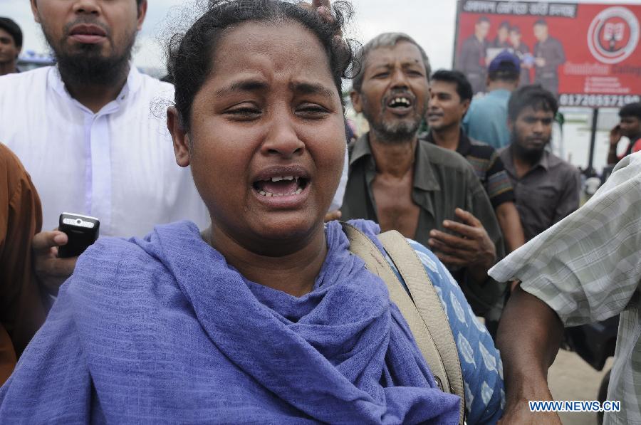 A woman mourns over her relative after a road accident at Ashuria on the outskirts of Dhaka, capital of Bangladesh, July 16, 2013. A passenger bus fell in to a river on the outskirts of Bangladesh's capital Dhaka Tuesday morning, leaving 5 people dead and 19 others missing, fire service officials said. (Xinhua/Shariful Islam)