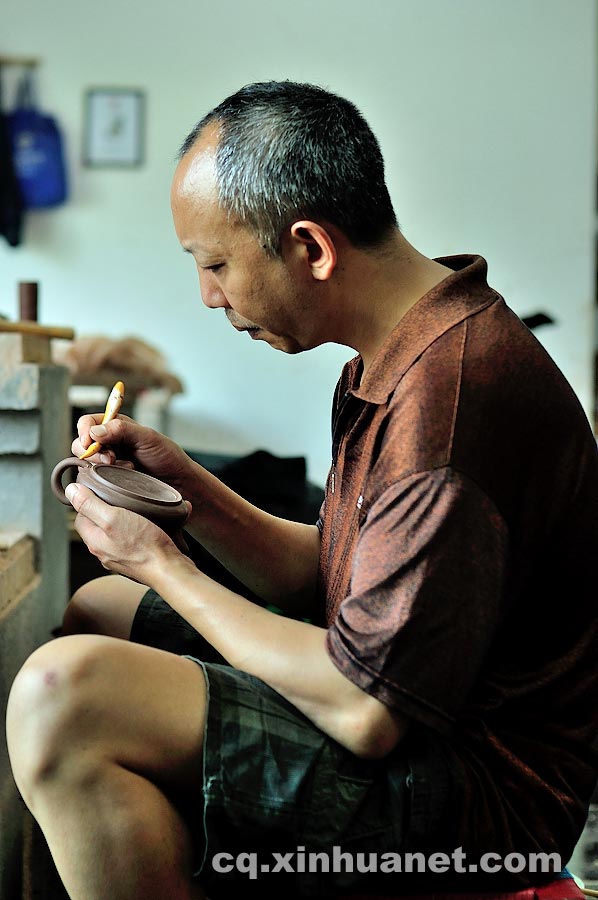 A craftsman does the final polishing for a teapot in a workshop in Anfu Town, Rongchang County, Chongqing, July 13, 2013. (Xinhua/Li Xiangbo)