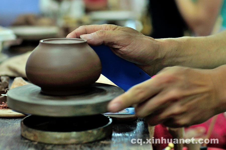 A craftsman rubs a teapot embryo in a workshop in Anfu Town, Rongchang County, Chongqing, July 13, 2013. (Xinhua/Li Xiangbo)