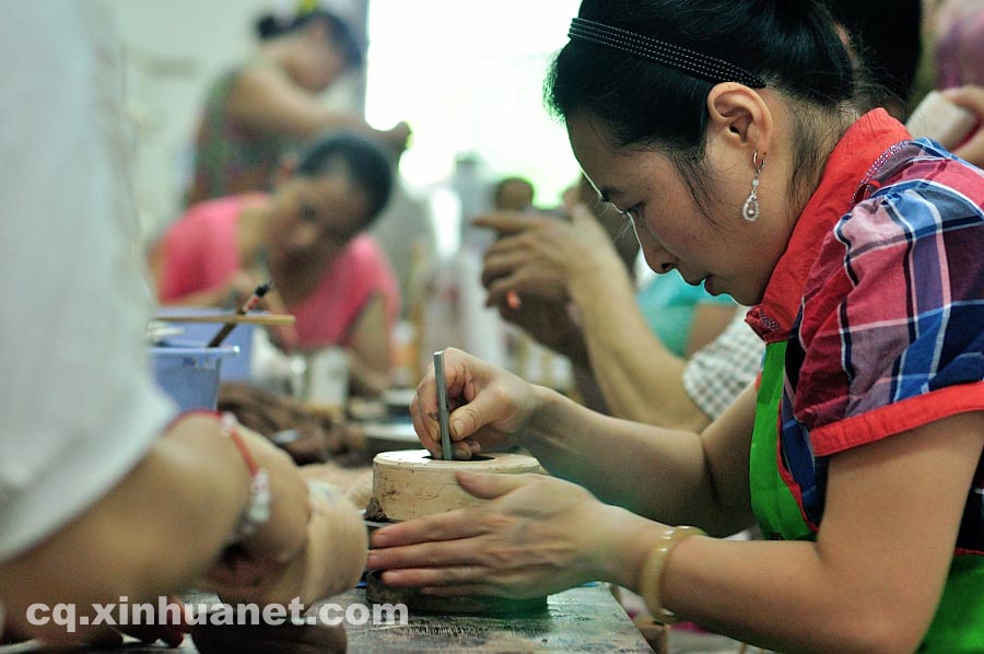 Craftsmen make teapot embryos in a workshop in Anfu Town, Rongchang County, Chongqing, July 13, 2013. (Xinhua/Li Xiangbo)
