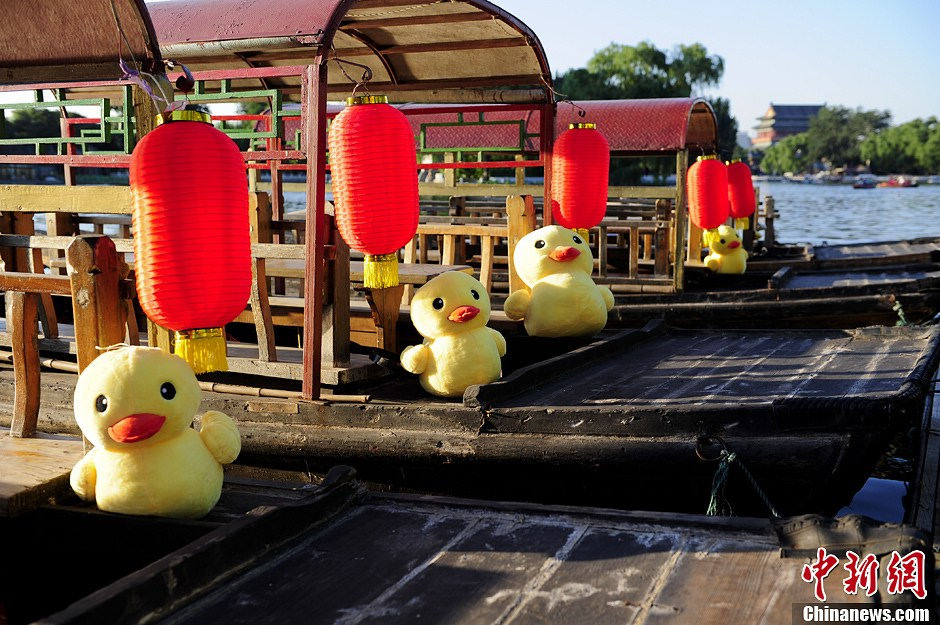 Little rubber ducks are “invited” to board the boats in Beijing's Shichahai Lake, July 16, 2013. The recent news saying that the Rubber Duck will visit Beijing this September has attracted Robber Duck fans’ attention. As one of the candidate places to host the Robber Duck, Shichahai Lake organized some events to welcome the Robber Duck. People who book group boat tickets online and take photos with little rubber ducks on the boat will get an authentic Rubber Duck doll. (Photo/Chinanews)