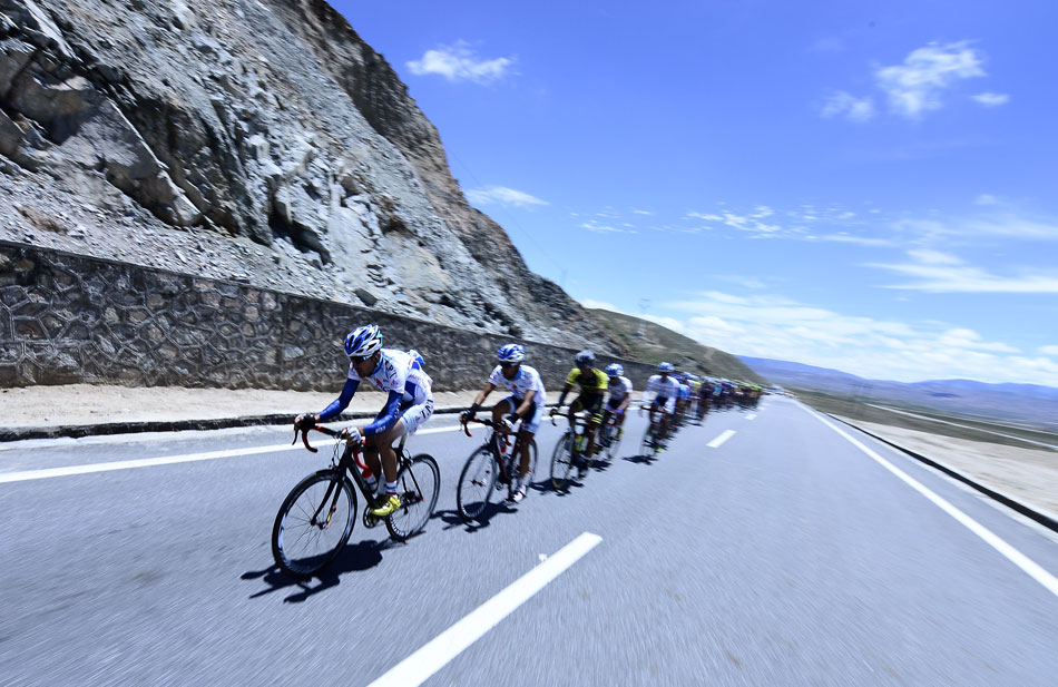 Racers compete in the fourth session of the Tour Round Qinghai Lake on July 10, 2013. The international road cycling has a total length of 227 kilometers around the Qinghai Lake this year. Sacha Modolo from Italy won the race. (Xinhua/ Zhang Hongxiang)