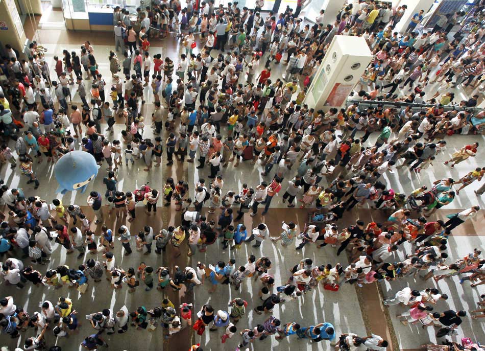 Parents line up for registration in the outpatient hall of Shanghai Paediatrics Hospital affiliated to Fudan University on July 9, 2013. The outpatient volume increased 30 percent for two consecutive weeks. Hot weather and the summer break were main cause of the increase of the outpatients. (Xinhua/Ding Ting)