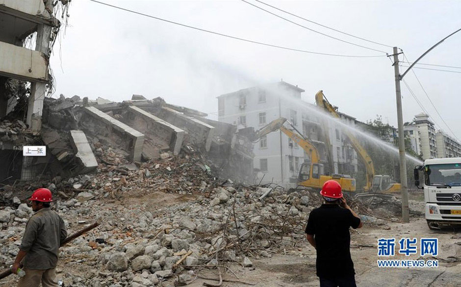 The teetering wall is pulled down in Wuhan on July 6. (Photo/Xinhua) 