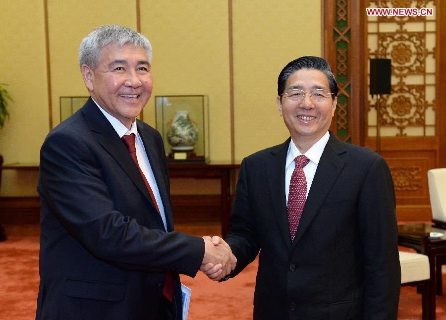Chinese State Councilor and Minister of Public Security Guo Shengkun (R) shakes hands with Kyrgyzstan's Interior Minister Abdylda Suranchiyev during their meeting in Beijing, capital of China, July 16, 2013. (Xinhua/Liu Jiansheng)