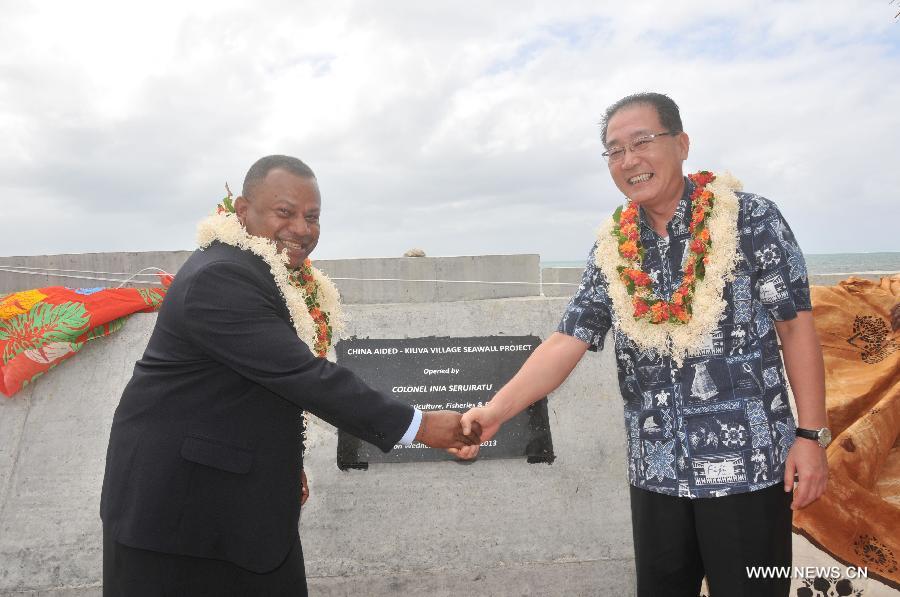 Chinese Ambassador to Fiji Huang Yong (R) shakes hands with Inia Seruiratu, Fiji' minister for rural and maritime development, after jointly commissioning the Kiuva village sea wall at Kiuva village, Tailevu province, Fiji, July 17, 2013. China on Wednesday donated a sea wall to Fiji, which became an example of the Fijian government's commitment to addressing sea level rise and protecting villages along coastal areas. (Xinhua/Michael Yang)