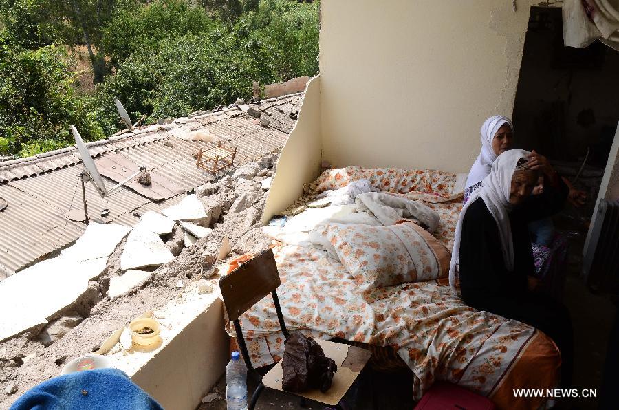 Two women sit in the ruins of their house collapsed in the earthquake shaking the locality of Hammam Melouene, in the province of Blida, 45 km south of Algiers, in Algeria, on July 17, 2013. An earthquake measuring 5.1 on the Richter scale on Wednesday hit Algeria's northern province of Blida, some 45 km south of capital Algiers, injuring 11 people, official APS news agency reported. (Xinhua/Mohamed Kadri)