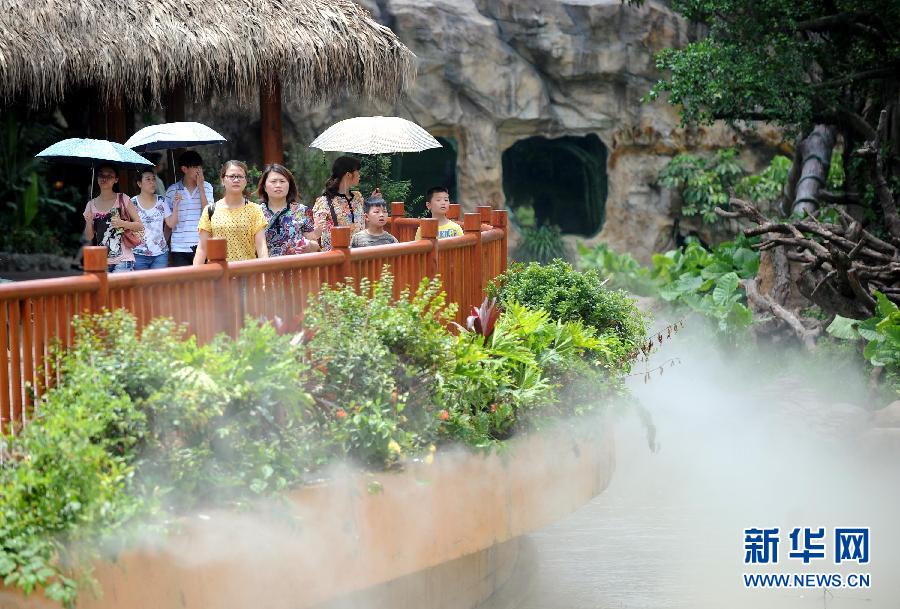 Tourists in Guangzhou Changlong Wildlife World on July 5, 2013. The temperature of Chongqing reached 35 degrees Celsius on the day. The weather station of Chongqing issued a yellow warning for high temperature. (Xinhua/Liu Dawei)