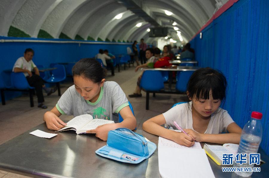 Students study in a dugout in Hefei, capital of northeast China's Anhui province on July 1, 2013. The municipality of Hefei opened the dugouts for public to enjoy the cool. (Xinhua/Du Yu)