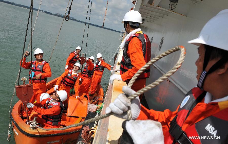Seamen participate in a maritime fire drill held by the South China Sea Navigation Support Center at the Qiongzhou Strait near Haikou, capital of south China's Hainan Province, July 18, 2013. (Xinhua/Guo Cheng) 
