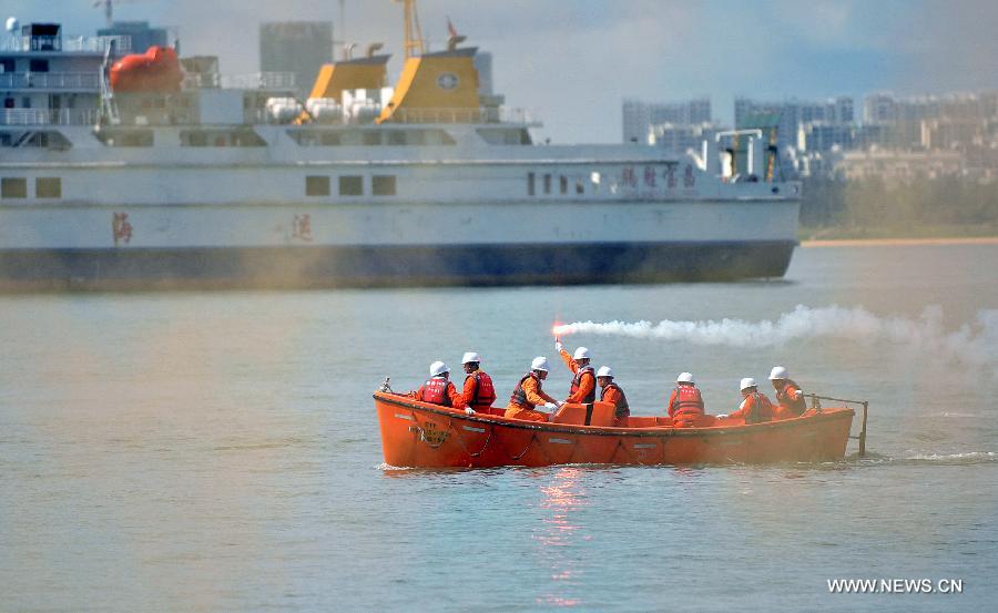 Seamen participate in a maritime fire drill held by the South China Sea Navigation Support Center at the Qiongzhou Strait near Haikou, capital of south China's Hainan Province, July 18, 2013. (Xinhua/Guo Cheng) 
