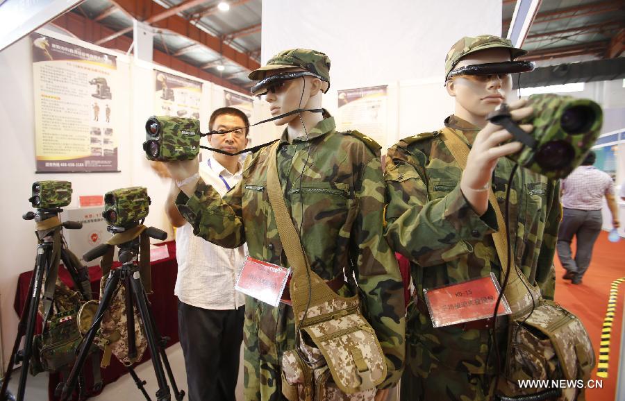A staff member layouts night vision equipments at the 2013 China International Exhibition on Public Safety and Security in Beijing, capital of China, July 18, 2013. The exhibition kicked off on Thursday at China International Exhibition Center. (Xinhua/Zhao Bing) 